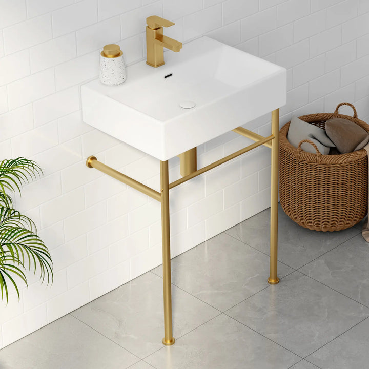 White wall-mounted rectangular sink with gold faucet and metal stand