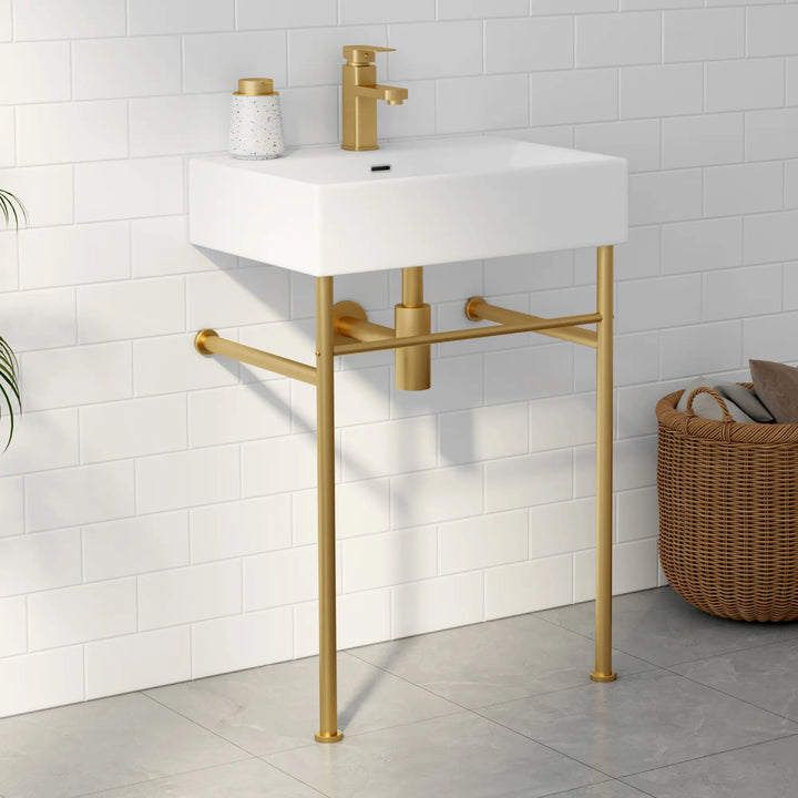 White wall-mounted rectangular sink with gold faucet and metal stand