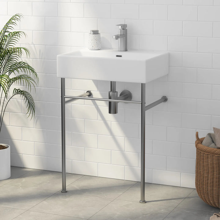 White ceramic wall-mounted sink with metal legs and single-hole faucet