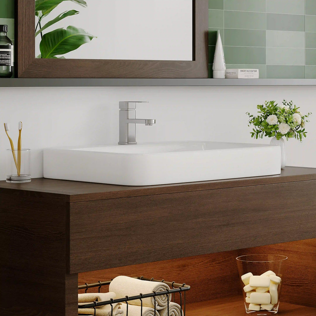 White ceramic long rounded vessel sink with square chrome faucet