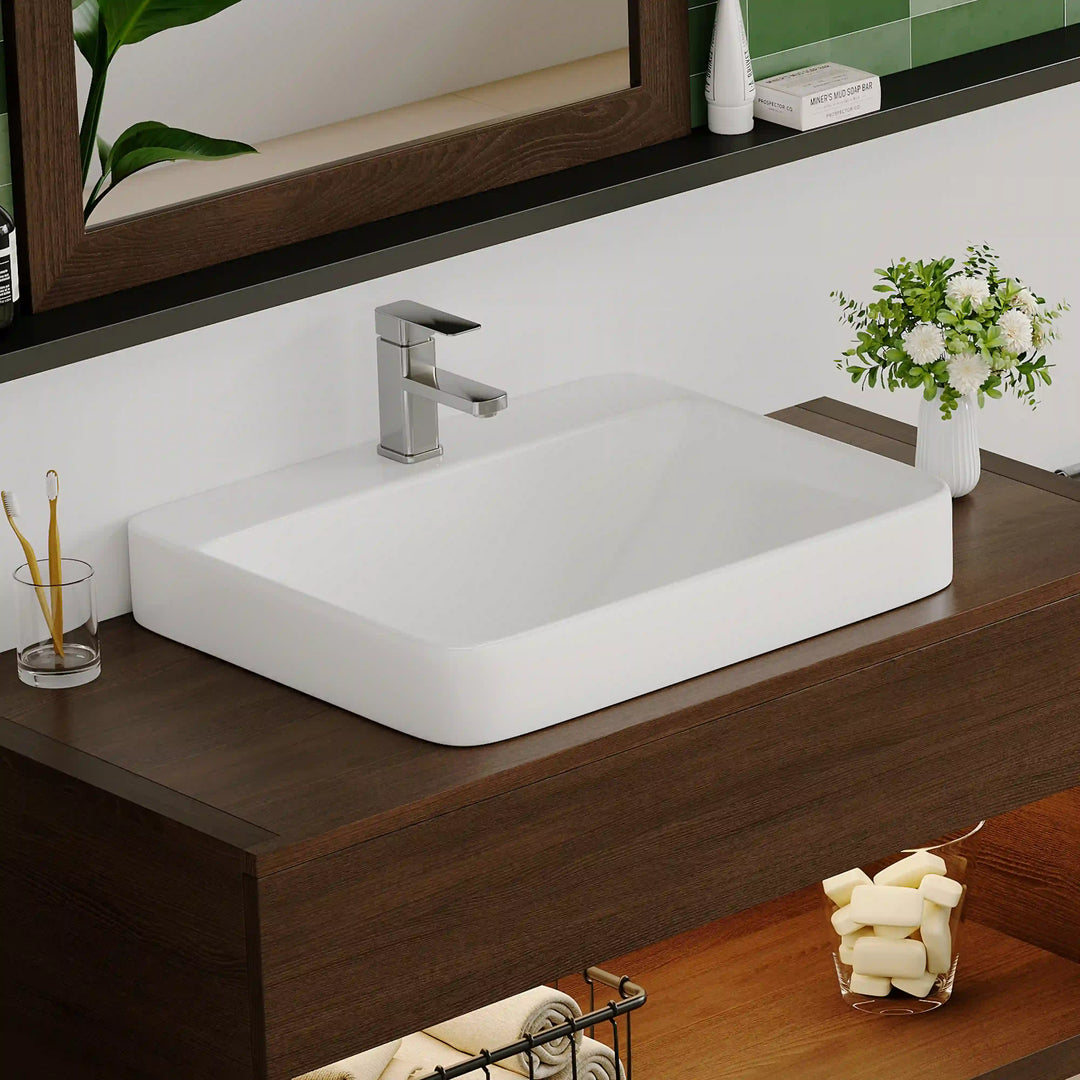 White ceramic rounded rectangular vessel sink with modern chrome faucet
