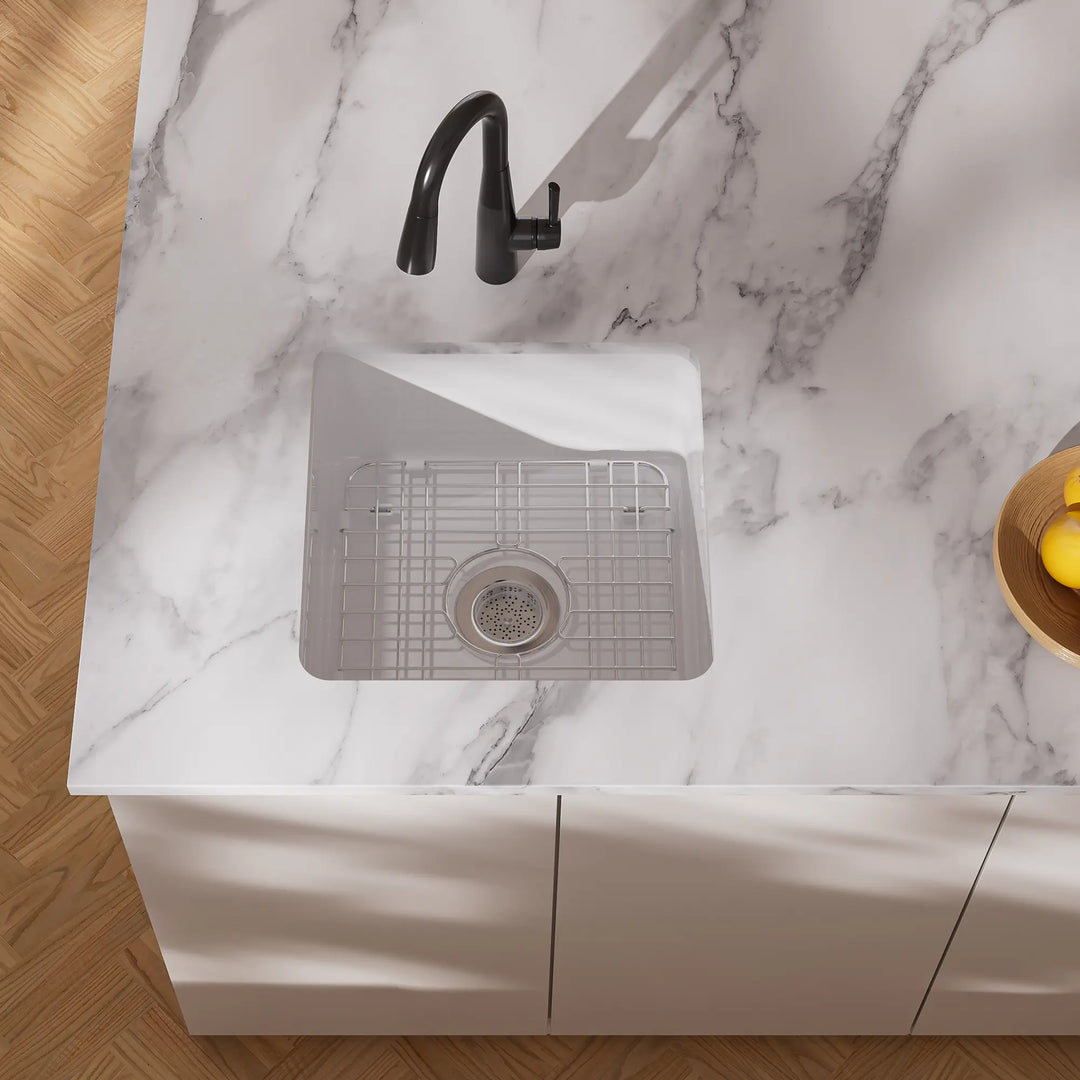 White undermount kitchen sink with black faucet and grid