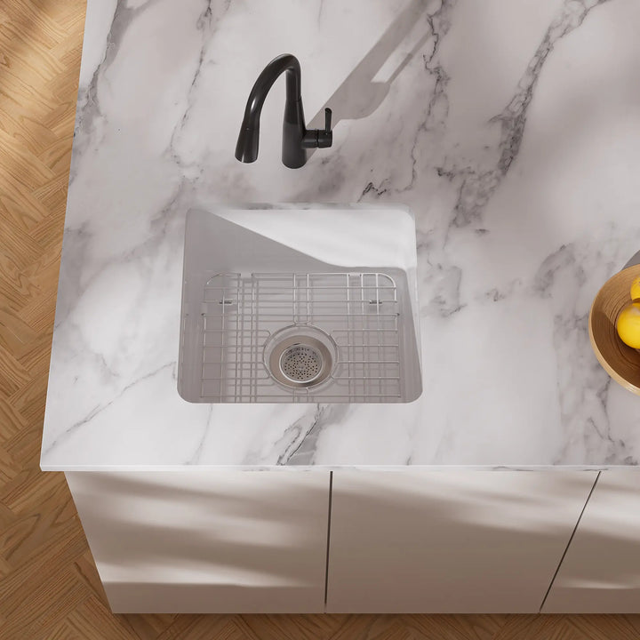 White undermount kitchen sink with black faucet and grid