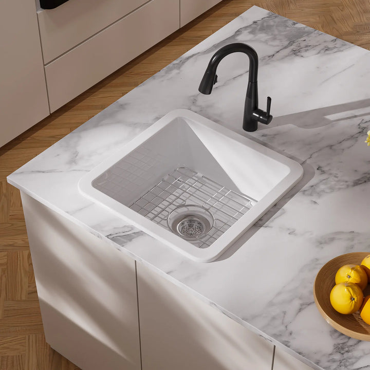 White drop-in kitchen sink with black faucet and grid