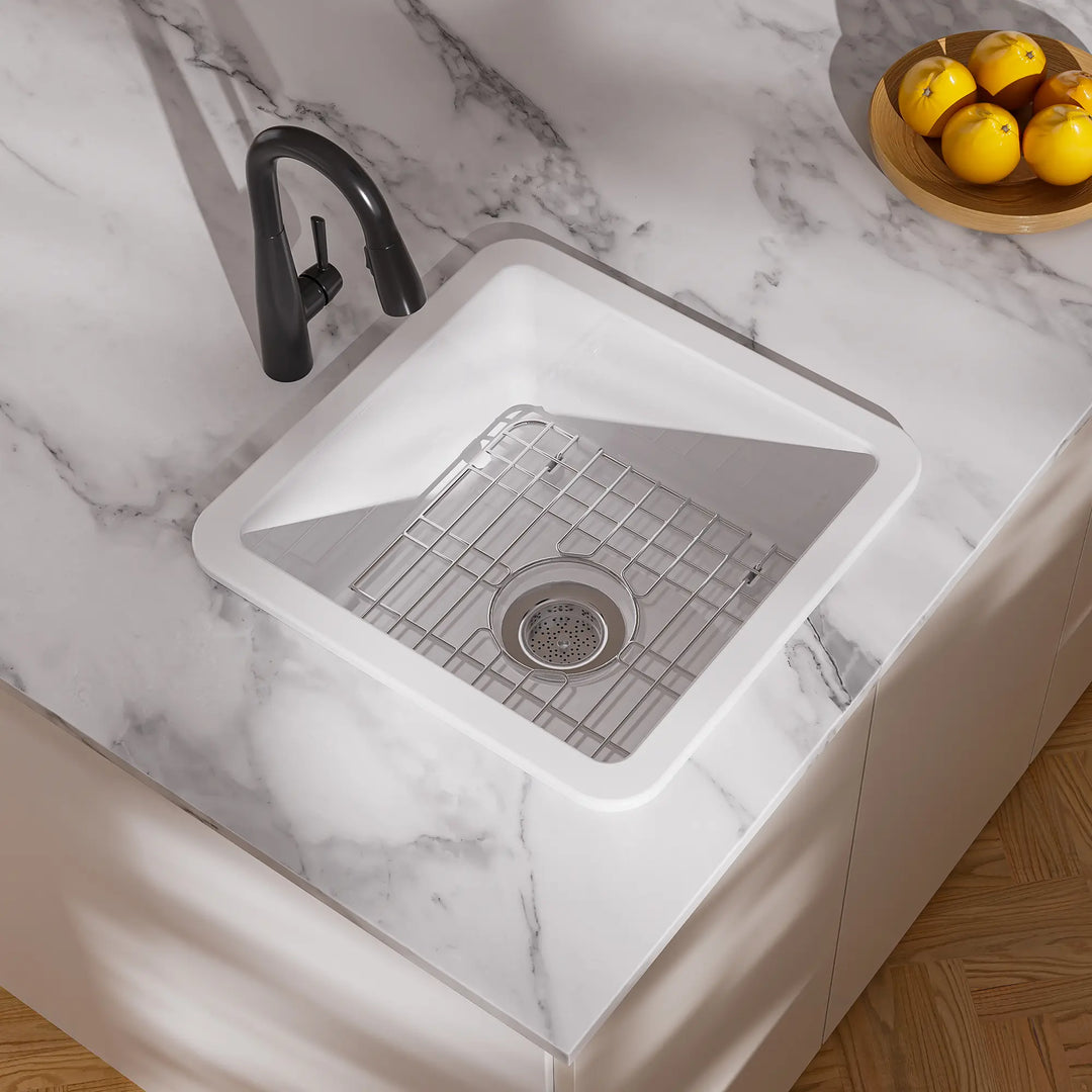 White drop-in kitchen sink with black faucet and grid