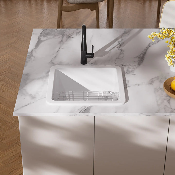 White drop-in kitchen sink with black faucet and grid