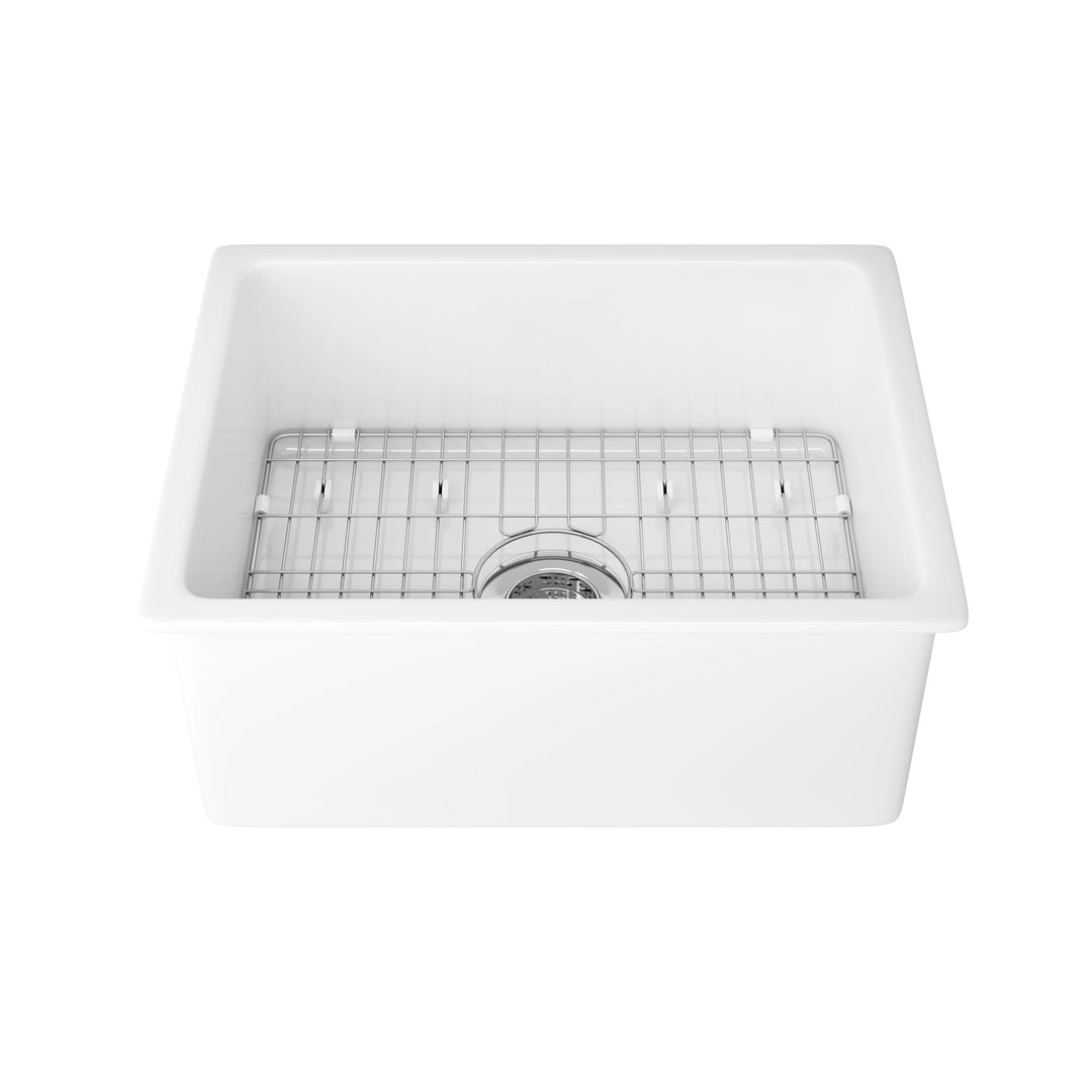 White farmhouse apron-front kitchen sink with stainless steel bottom grid and center drain.