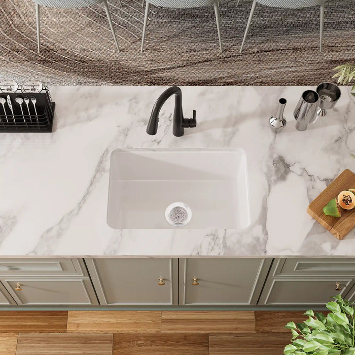 White undermount kitchen sink with black faucet and grid