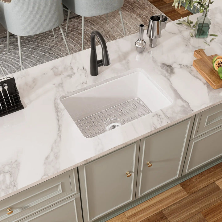 White fireclay undermount sink with black faucet and grid