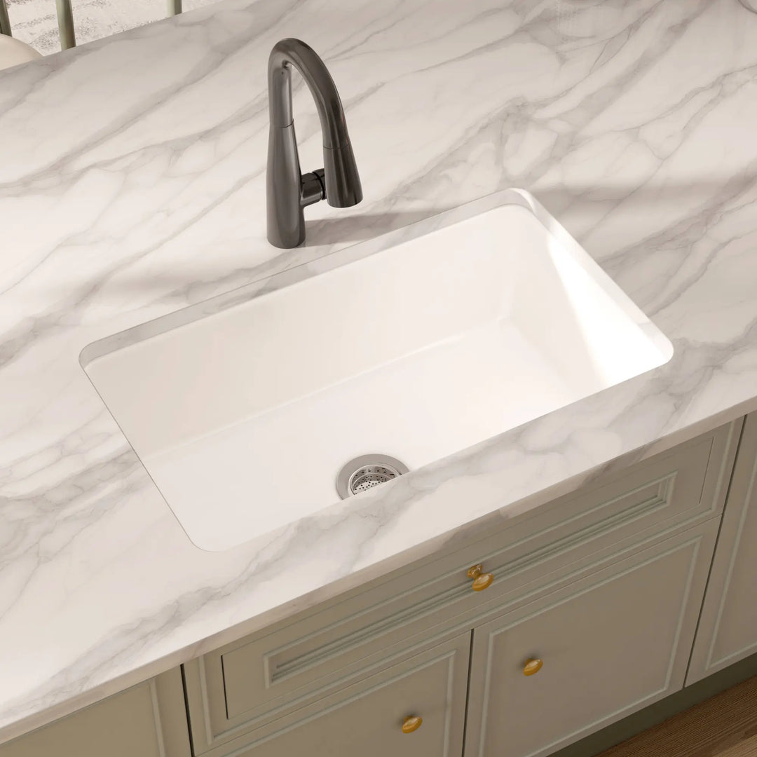 White rectangular undermount fireclay kitchen sink with black faucet