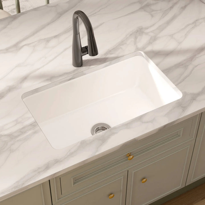 White rectangular undermount fireclay kitchen sink with black faucet