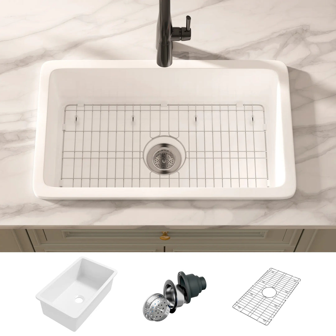 White rectangular fireclay kitchen sink with bottom grid and basket strainer