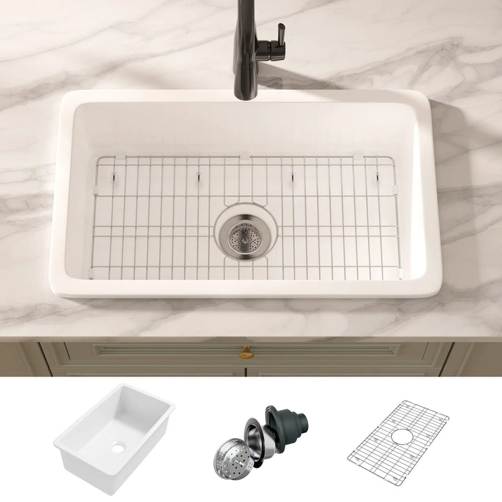 White rectangular fireclay kitchen sink with bottom grid and basket strainer