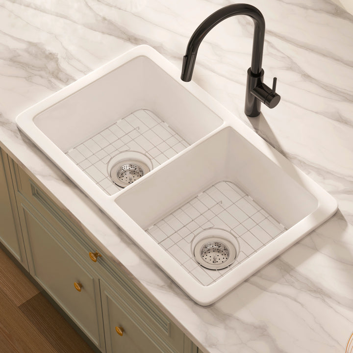 White topmount double-bowl kitchen sink with stainless steel bottom grids and strainers.