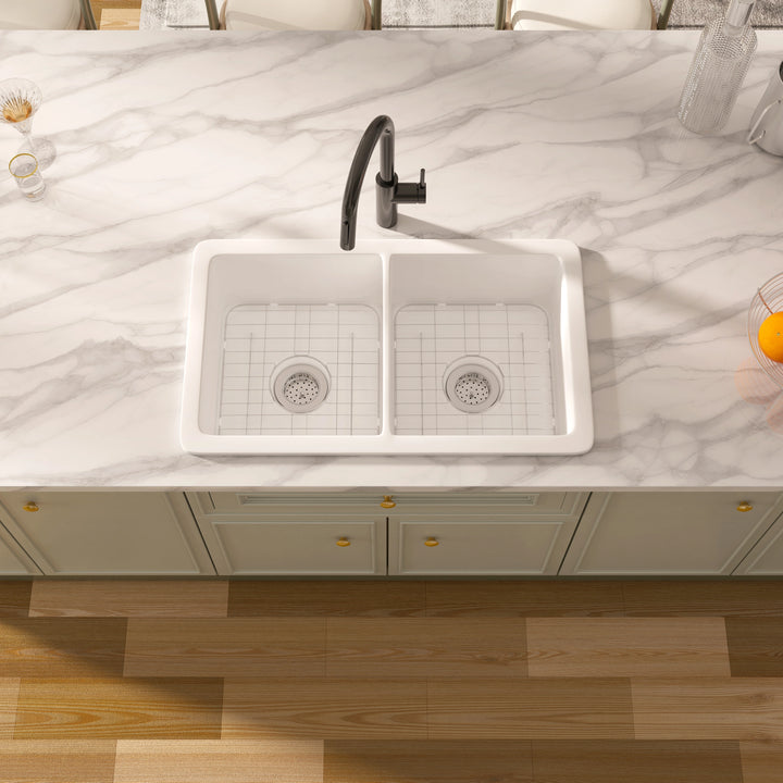 White double-bowl kitchen sink with bottom grids and black faucet.
