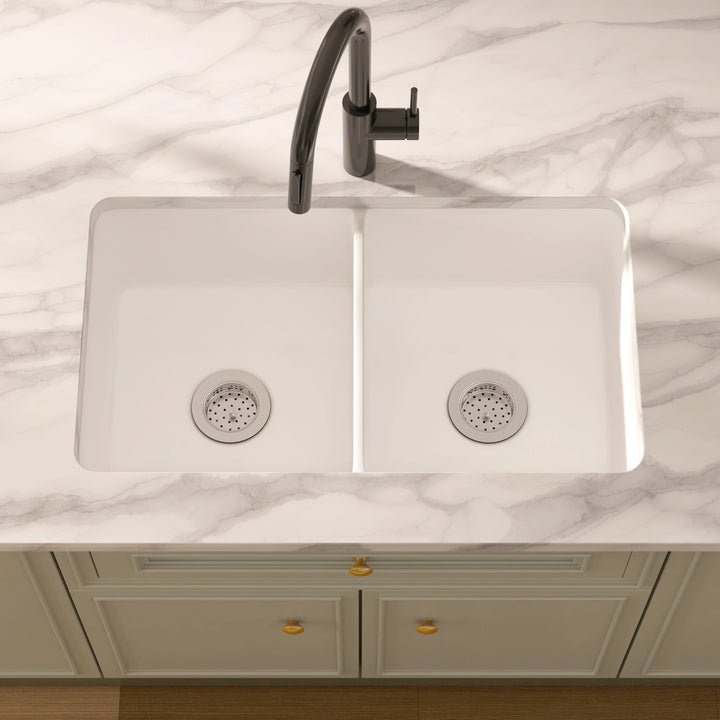 White composite double-bowl undermount kitchen sink with stainless steel strainers.