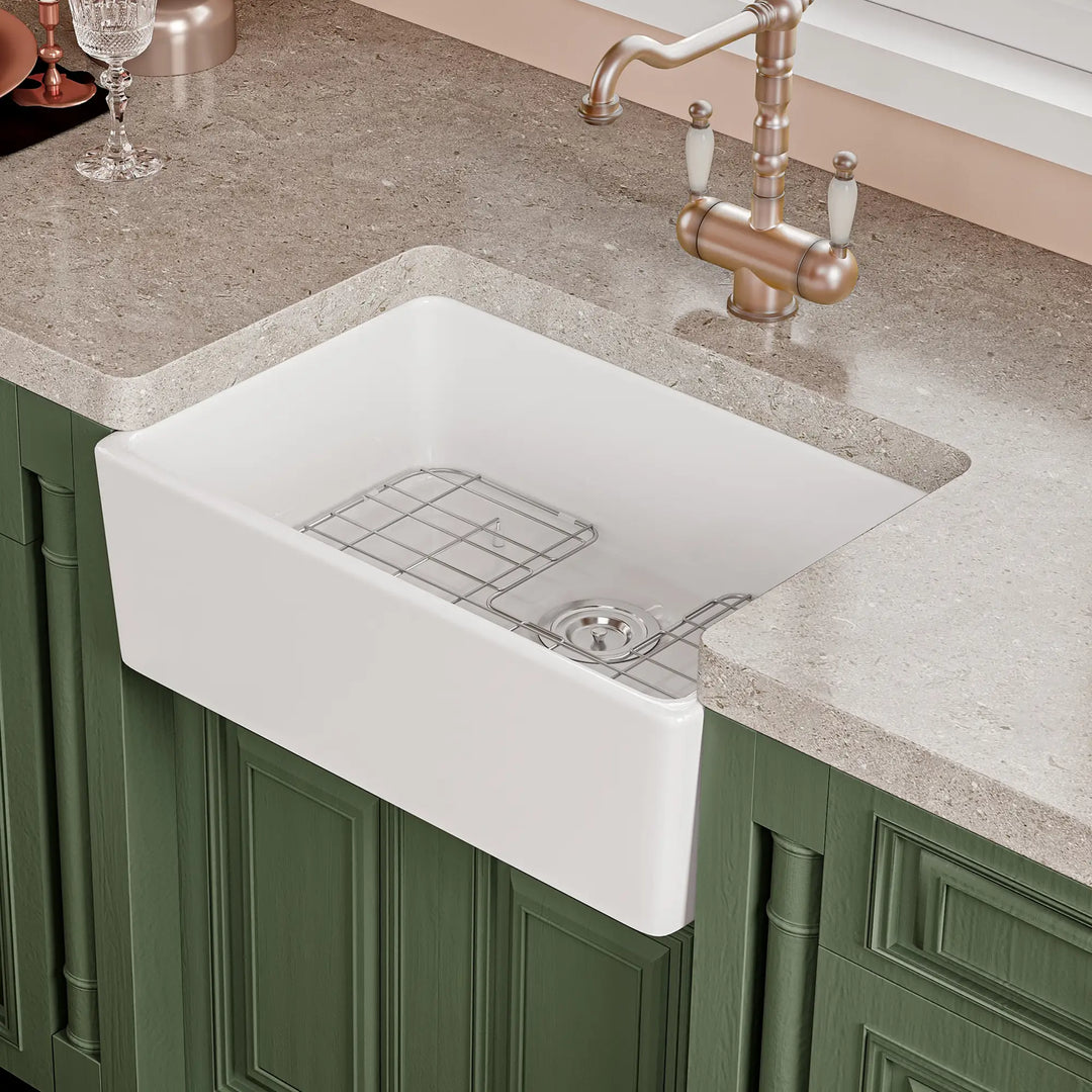 White fireclay farmhouse kitchen sink with apron front and bottom grid