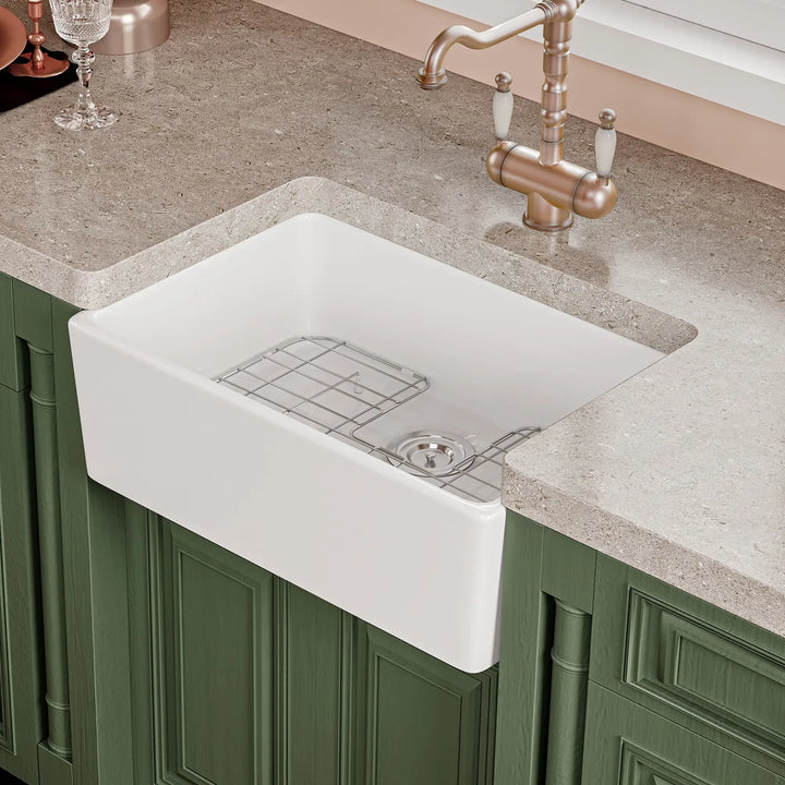 White fireclay farmhouse kitchen sink with apron front and bottom grid