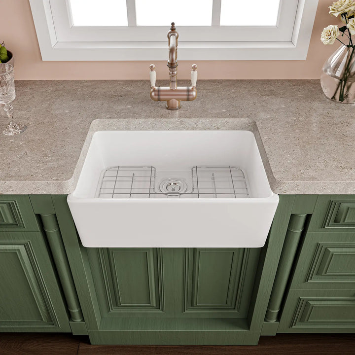 White fireclay farmhouse kitchen sink with apron front and grid