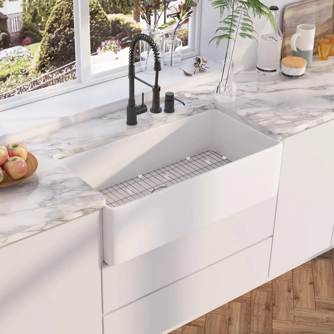 White fireclay apron front single bowl kitchen sink with stainless steel grid and matte black faucet set
