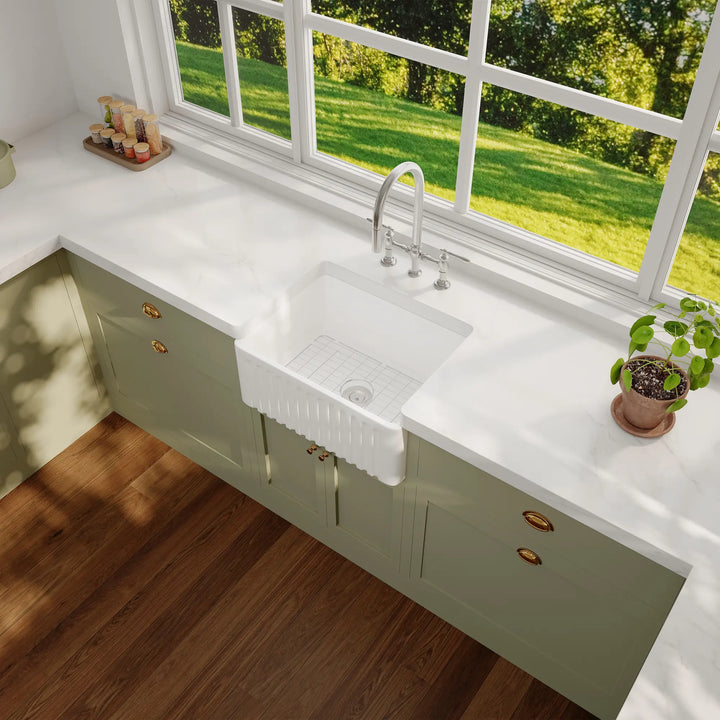 White ceramic farmhouse sink with fluted apron and bottom grid