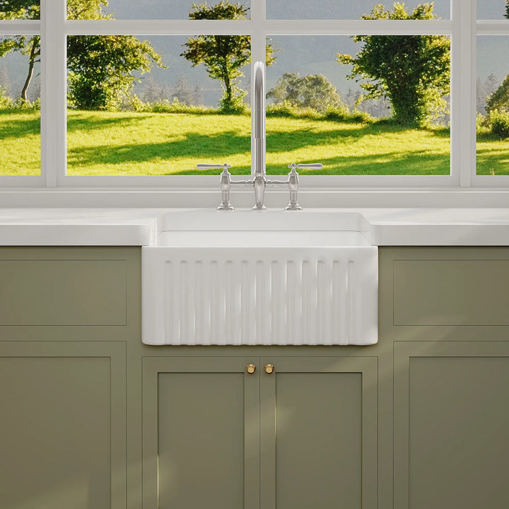 White ceramic farmhouse sink with fluted apron front design