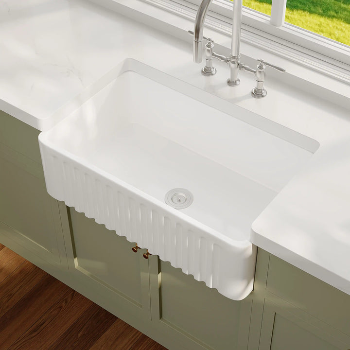 White fluted apron front fireclay single bowl farmhouse kitchen sink with rounded interior corners