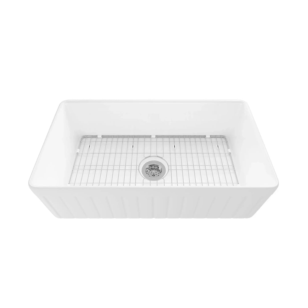 White fireclay single bowl farmhouse sink with fluted apron and stainless steel bottom rack