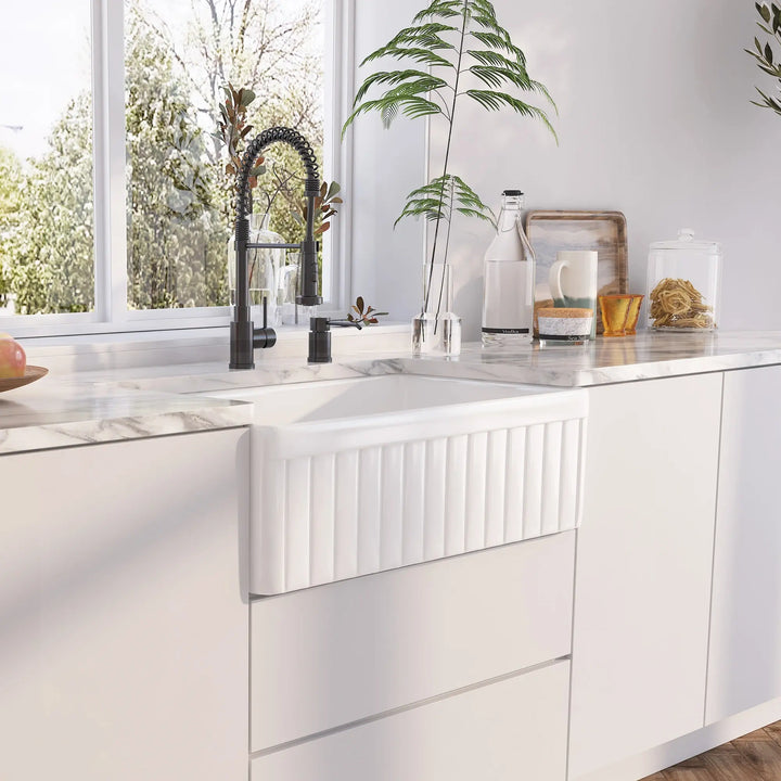 White fireclay farmhouse sink front panel with vertical fluted ribbed texture