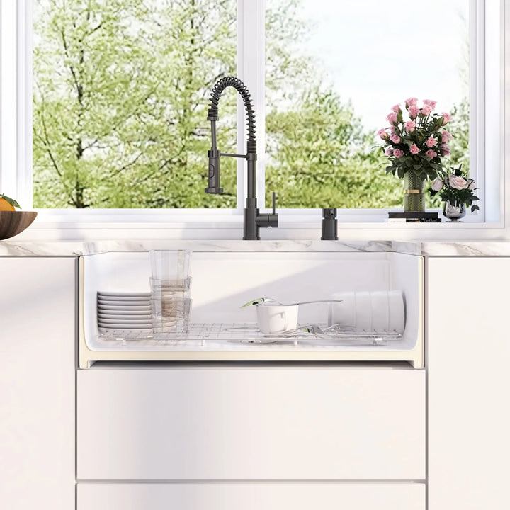 White fireclay single farmhouse sink fitted with stainless steel protective bottom grid