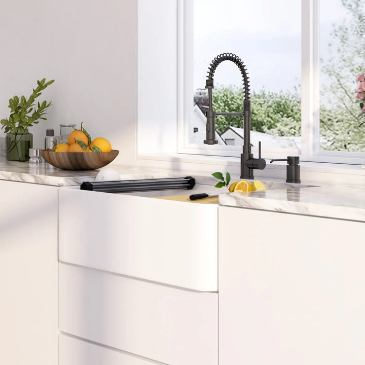 White fireclay single bowl farmhouse sink with roll-up rack and bamboo cutting board