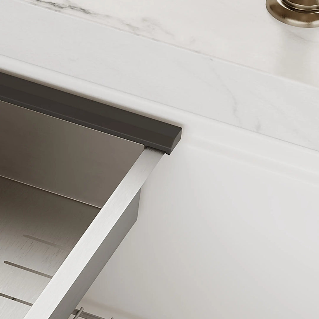 Stainless steel colander detail on white workstation sink