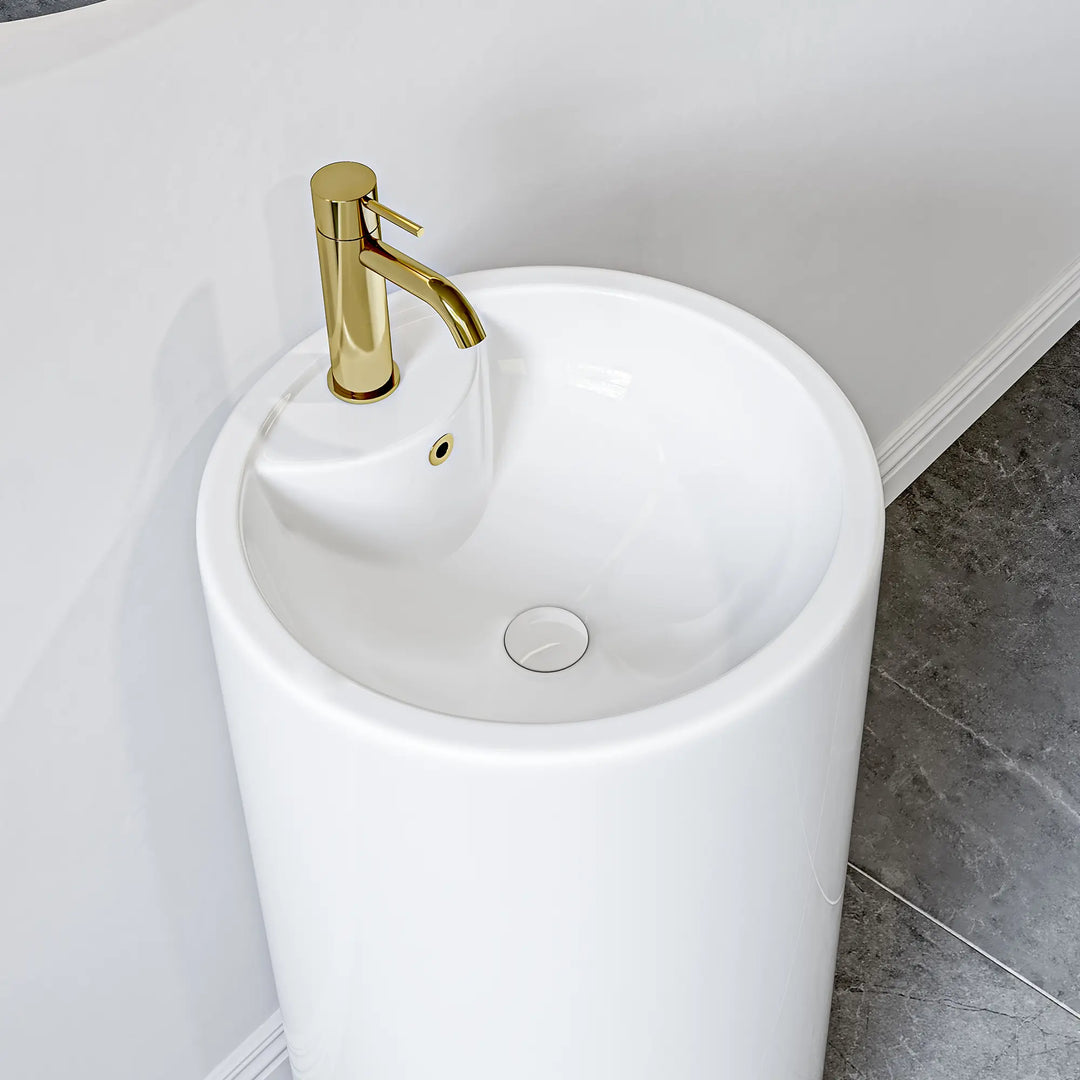 White freestanding pedestal sink with gold faucet