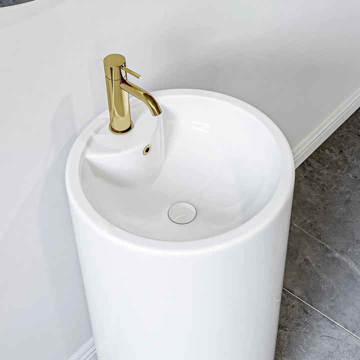 White freestanding pedestal sink with gold faucet