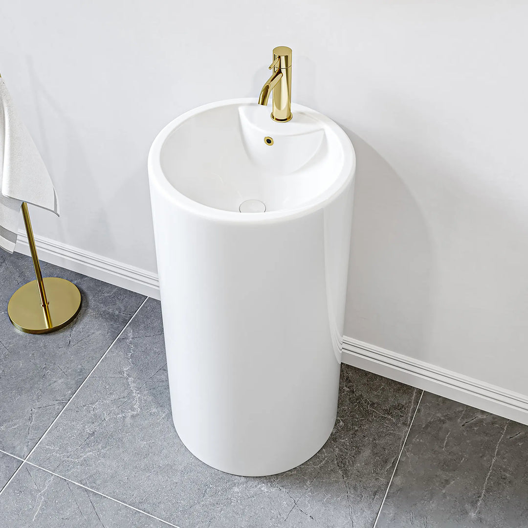 White freestanding pedestal sink with gold faucet