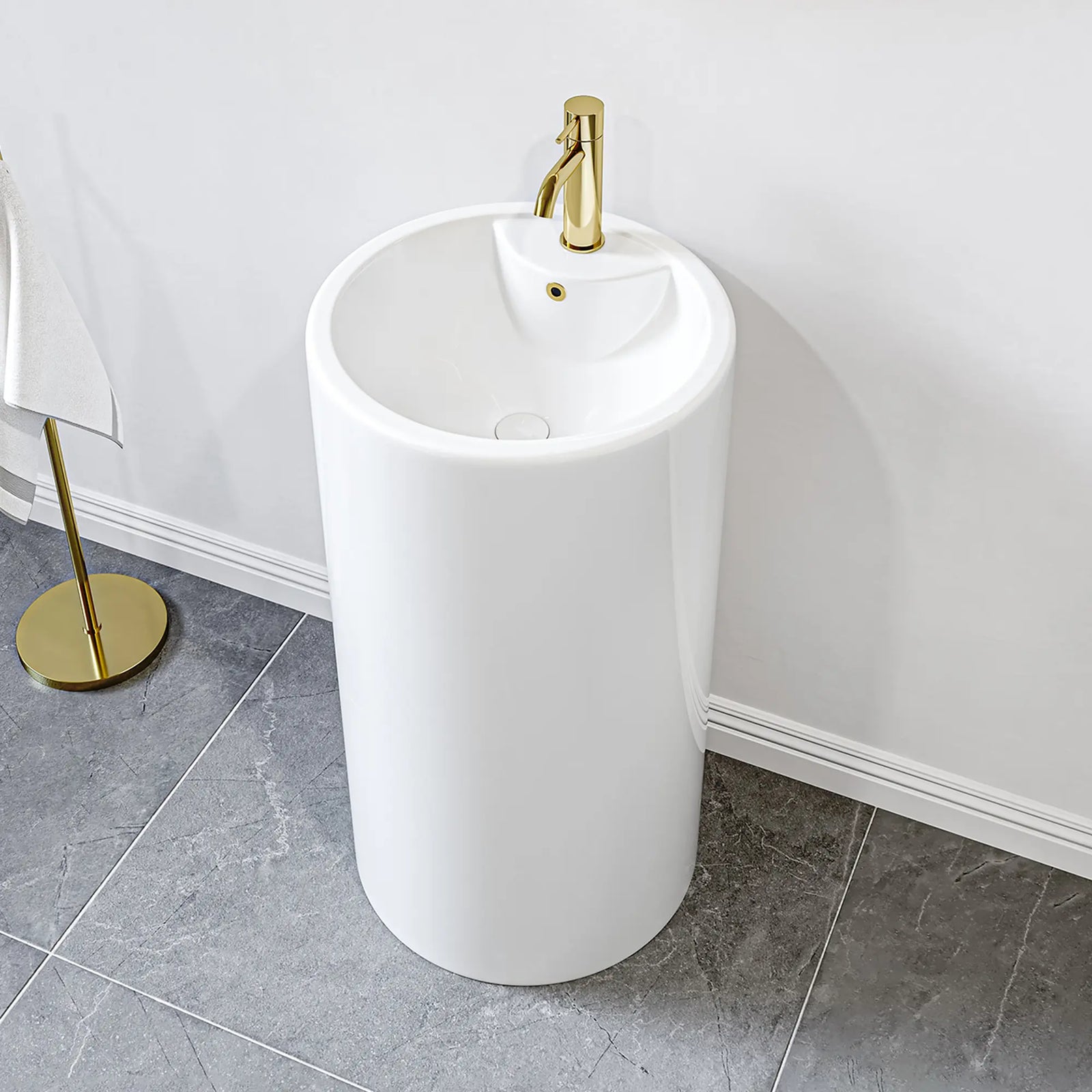 White freestanding pedestal sink with gold faucet