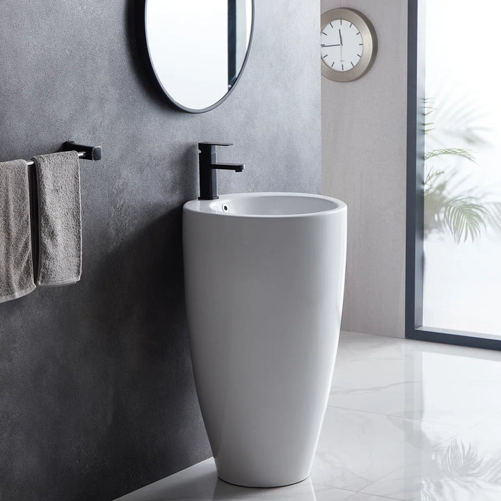 White freestanding pedestal sink with round basin and black faucet