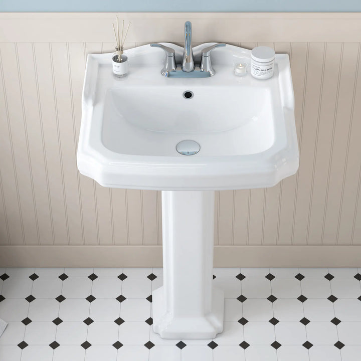 White ceramic pedestal sink with chrome centerset faucet.