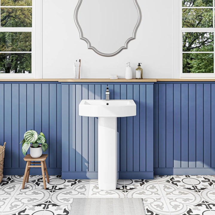 White ceramic pedestal sink with modern chrome faucet