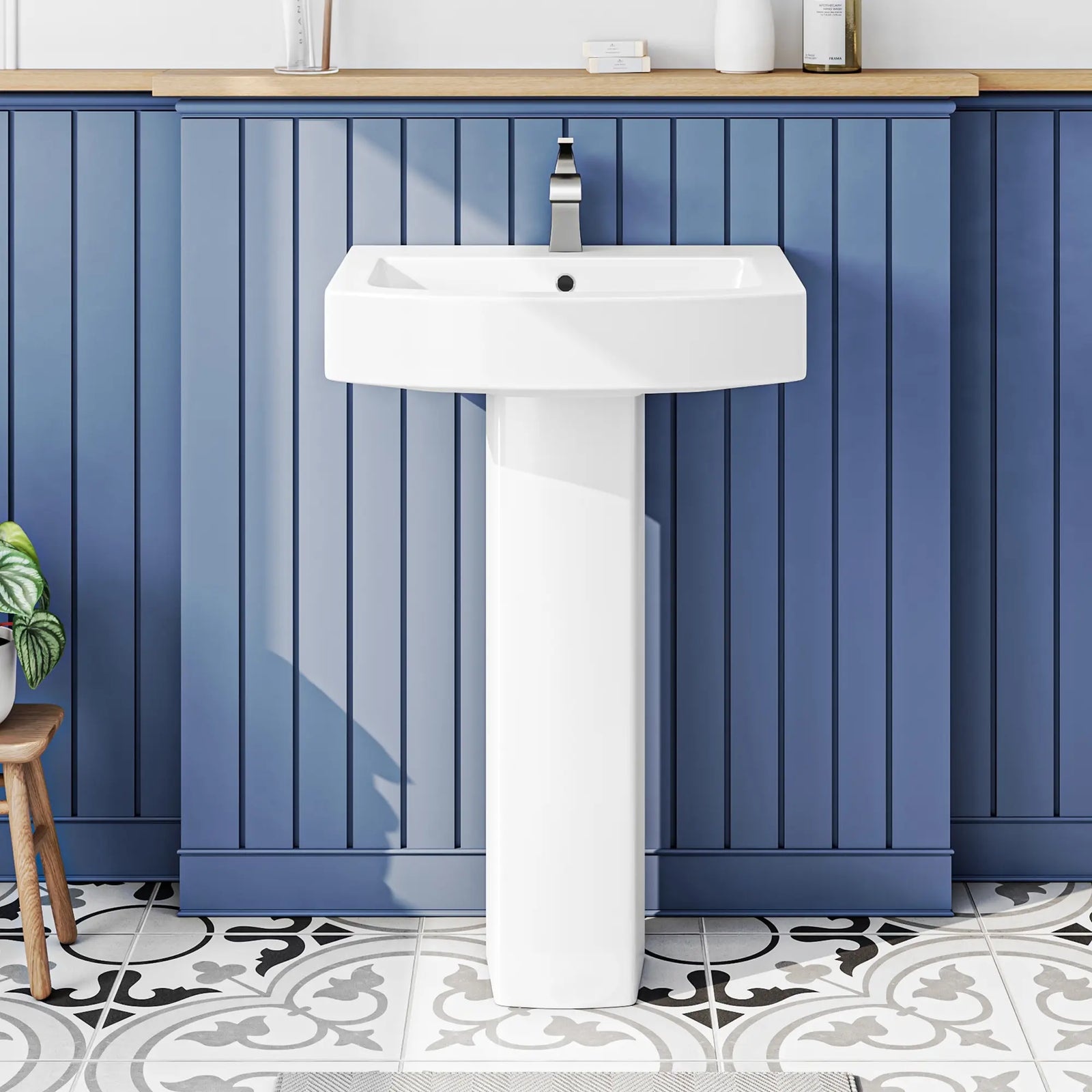 White ceramic pedestal sink with modern chrome faucet