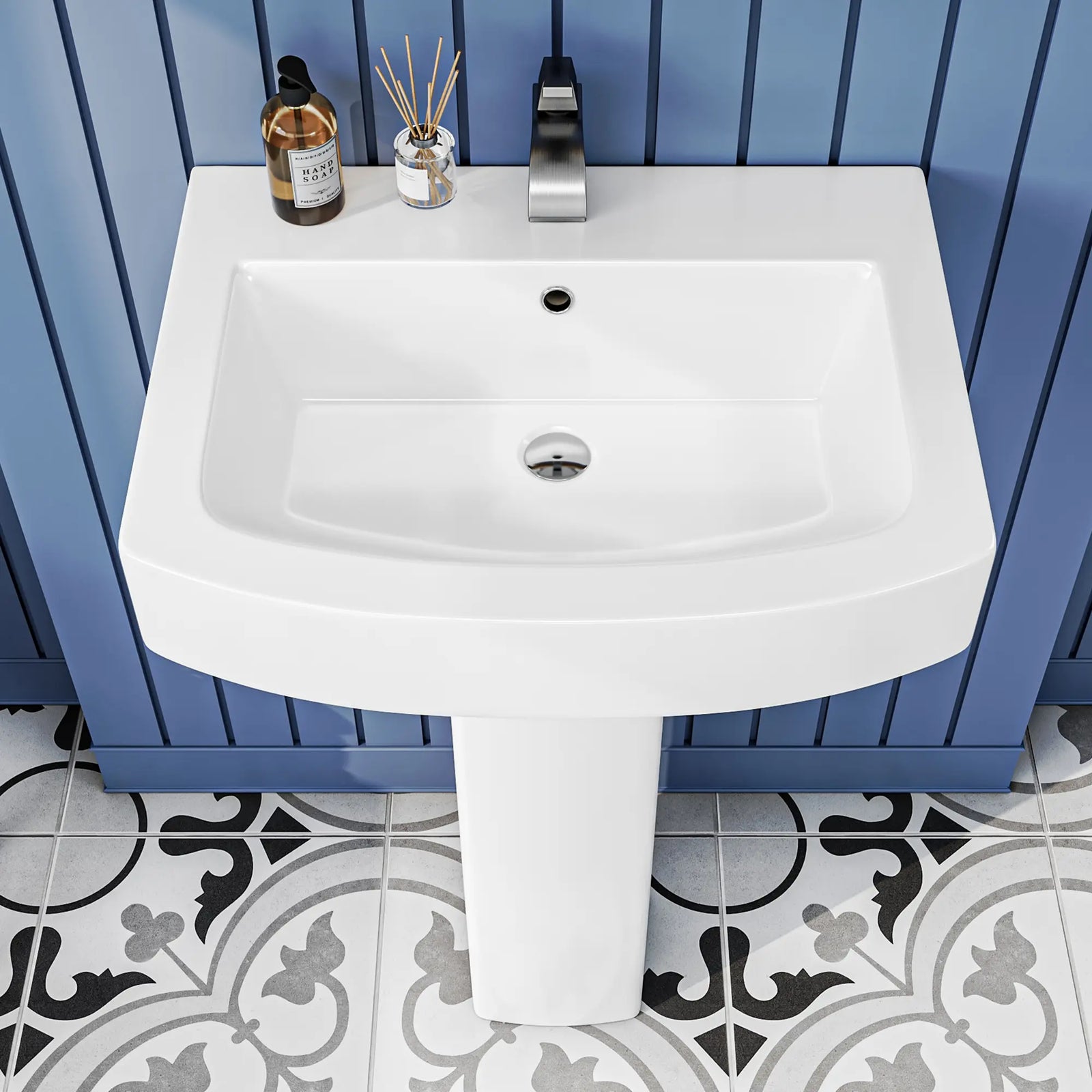 White ceramic pedestal bathroom sink with modern faucet