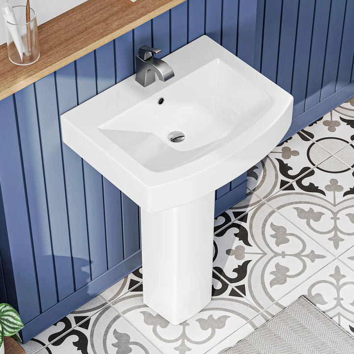 White ceramic pedestal sink with modern chrome faucet