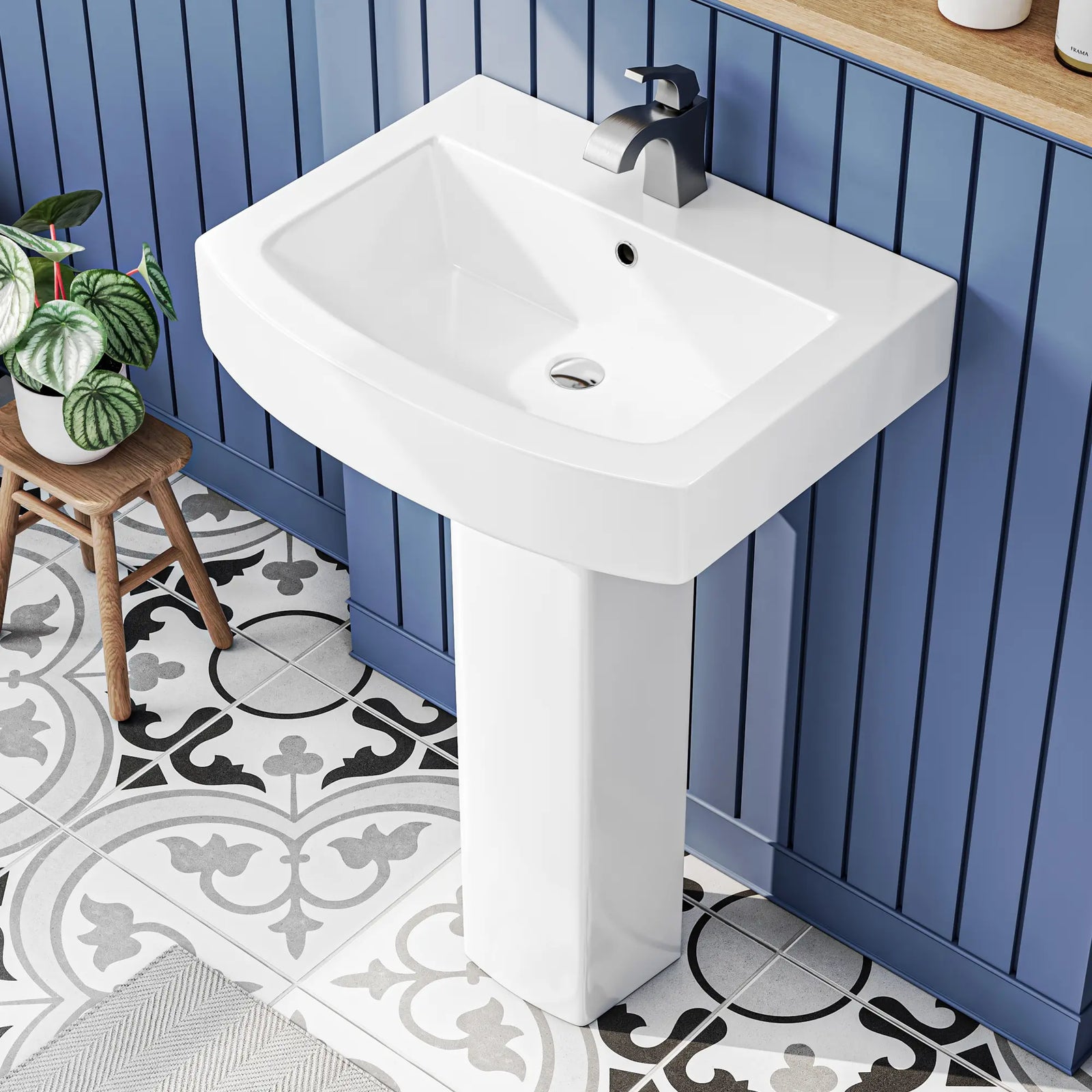 White ceramic pedestal bathroom sink with modern faucet