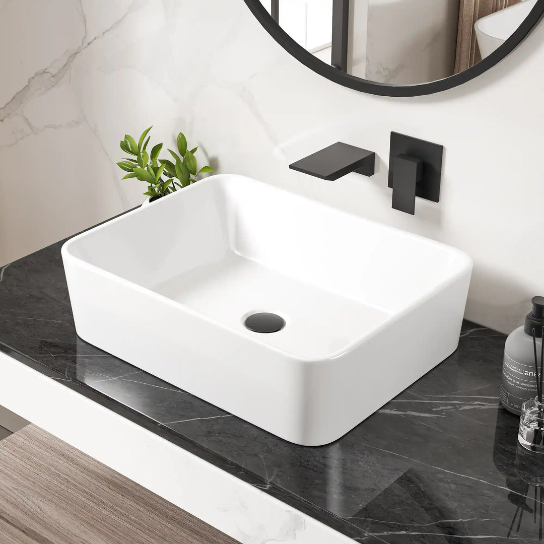 White rectangular ceramic countertop vessel sink with matte black wall-mounted faucet