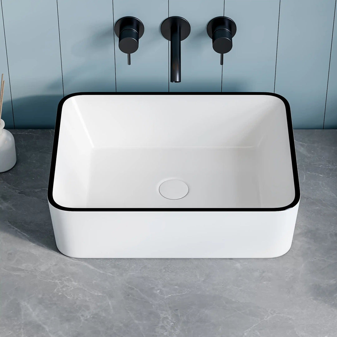 White rectangular ceramic vessel sink with thin black edge and matte black wall faucet set