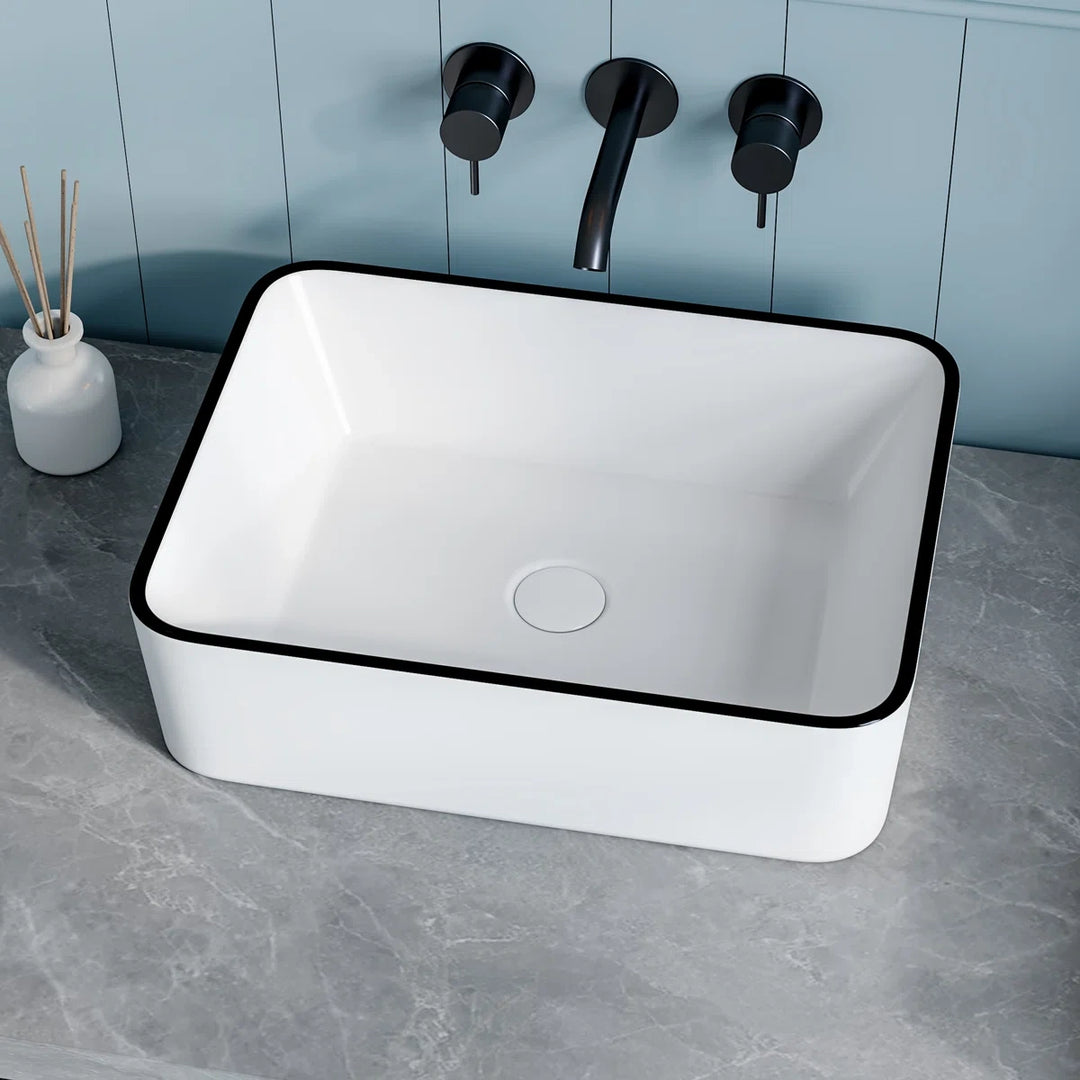 White rectangular vessel sink with modern black rim design.