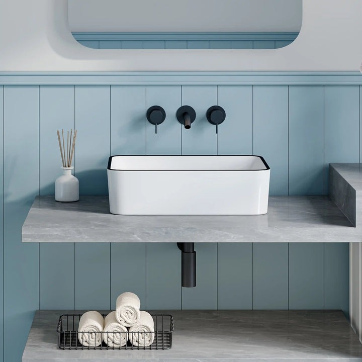 Long white ceramic vessel sink with thin black trim and matte black wall tap set