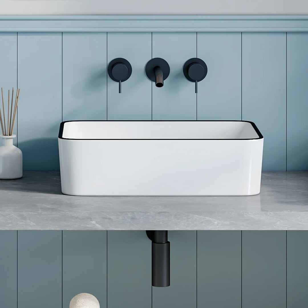 Black rimmed white vessel sink for flexible countertop mounting.
