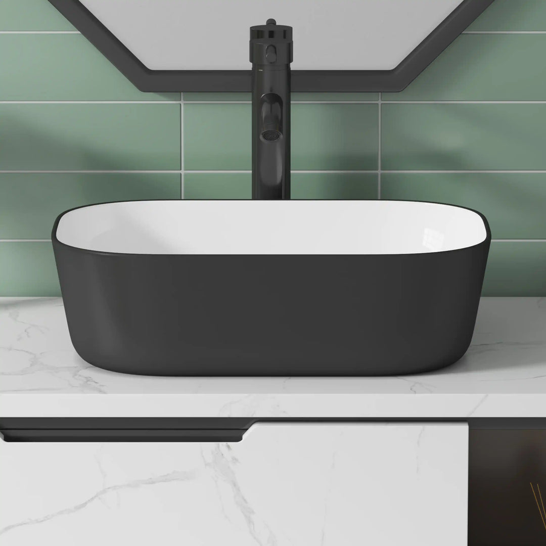 Matte black exterior white interior rectangular ceramic vessel sink with rounded corners