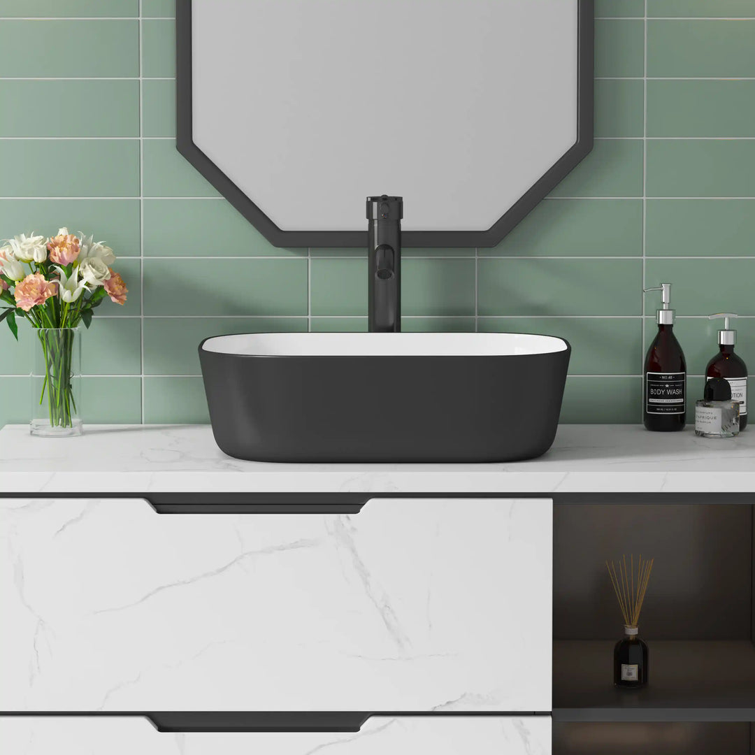 Matte black exterior white interior rectangular ceramic vessel sink with rounded corners